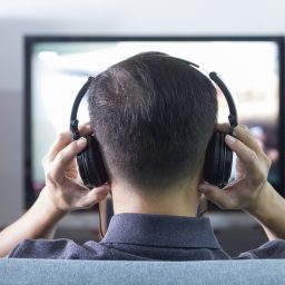 man wearing headphones while watching tv