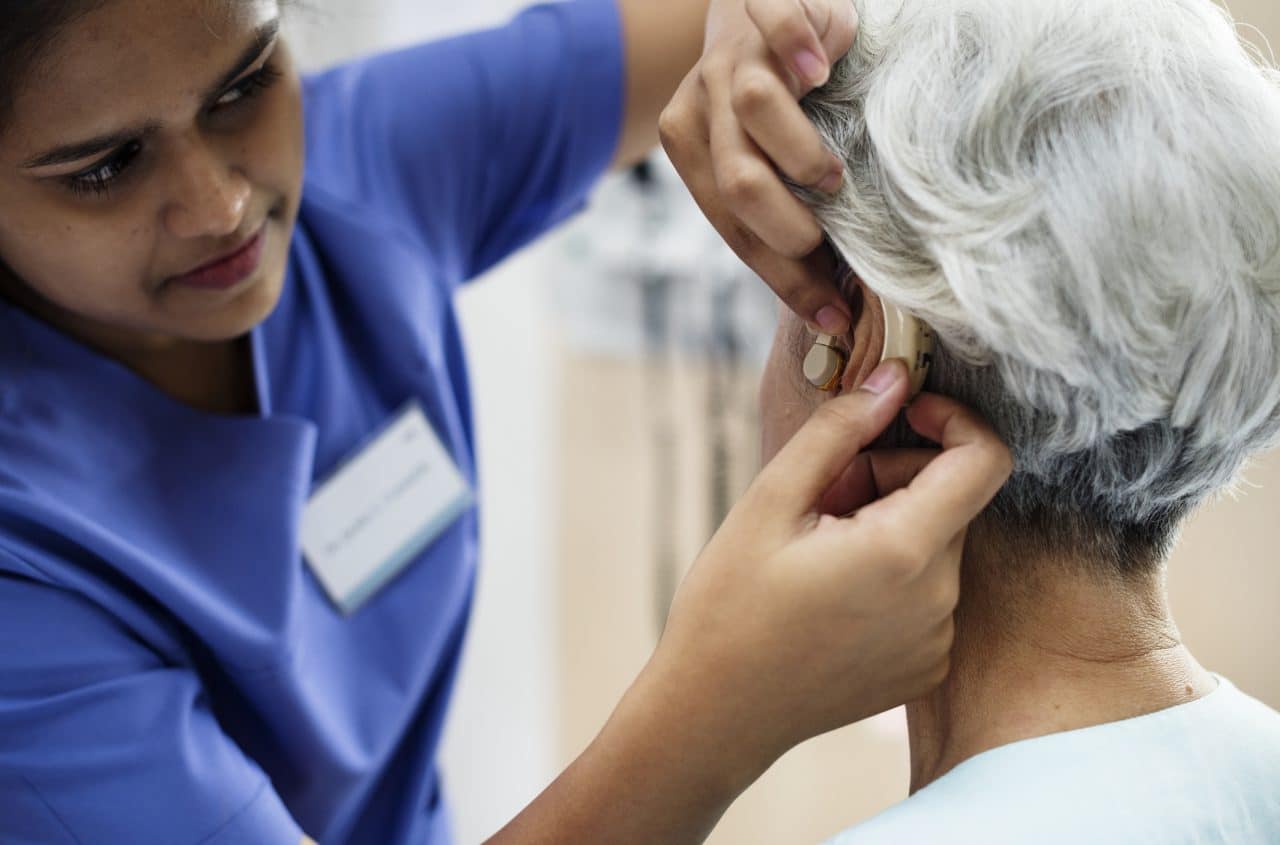 Woman getting her hearing aid adjusted.