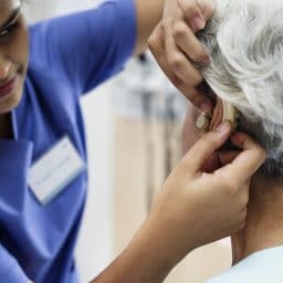 Woman getting her hearing aid adjusted.