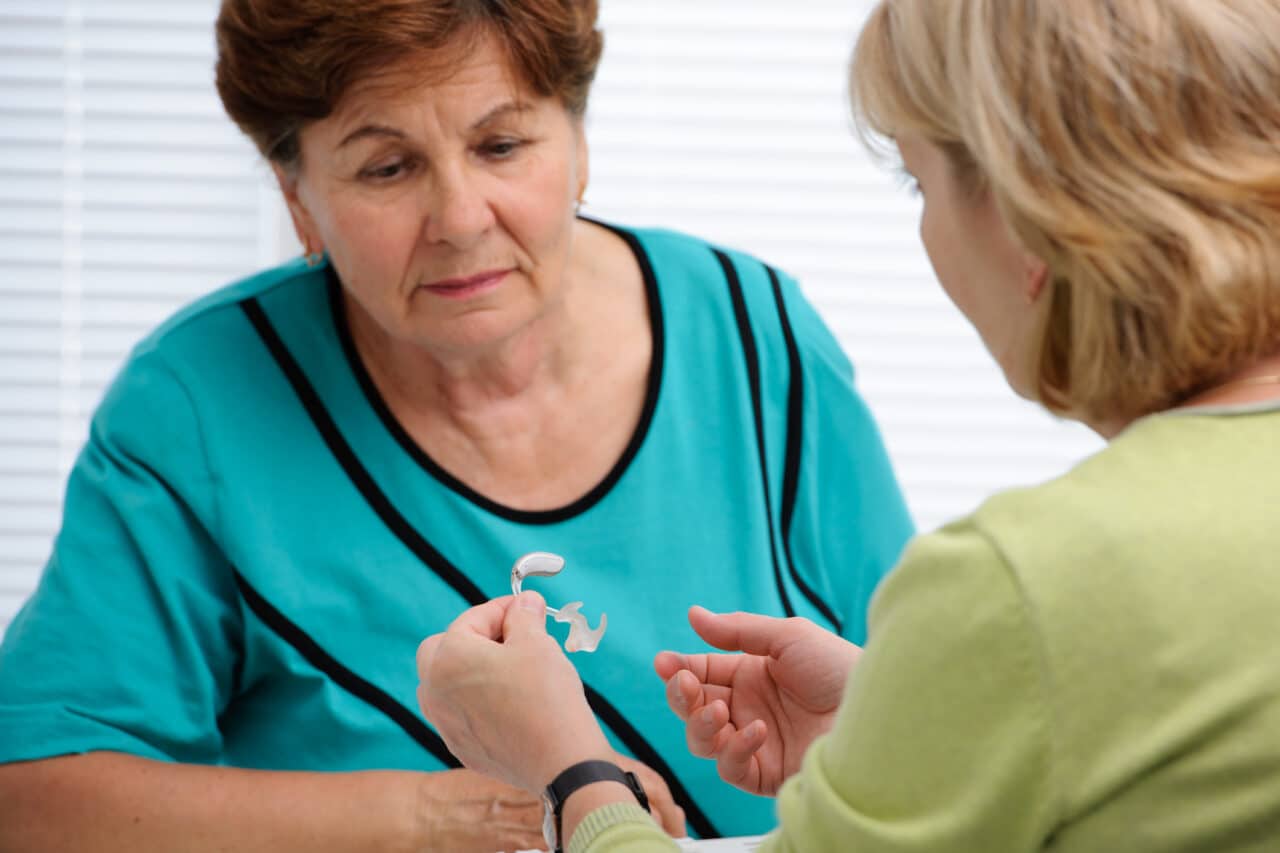 Audiologist explaining to a patient how hearing aids work.