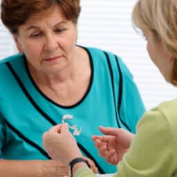 Audiologist explaining to a patient how hearing aids work.