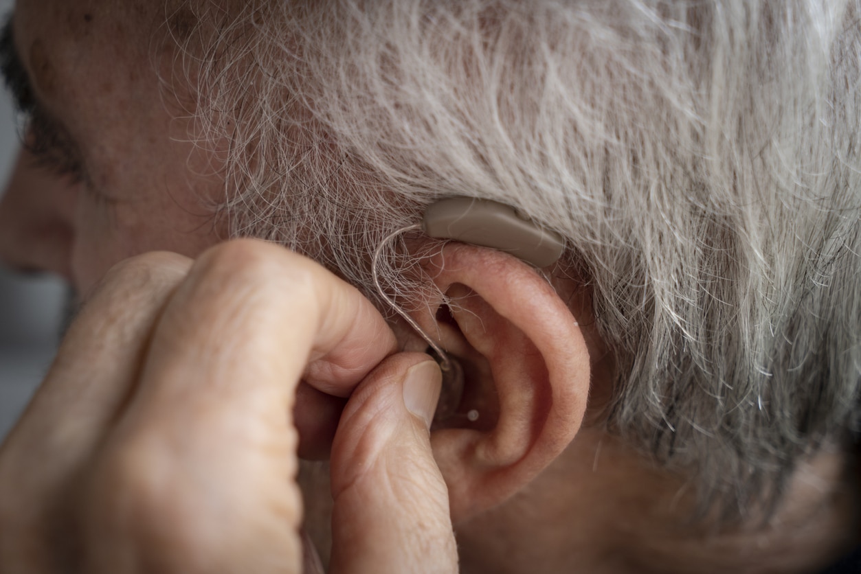 Close up of man adjusting hearing aid