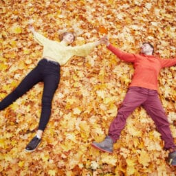 Young couple laying in the autumn leaves